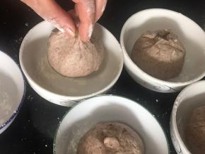 再把小面团对折三次，再滚圆，收口朝上放入抹好粉底的碗中，密封发酵至两倍以上