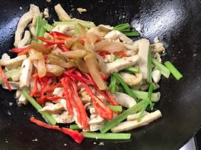 加入红辣椒丝和榨菜，翻炒片刻至入味