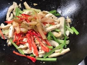 加入红辣椒丝和榨菜，翻炒片刻至入味