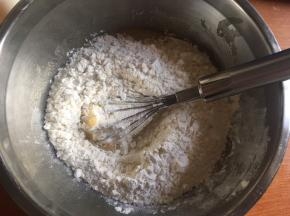 将面粉、苏打粉、泡打粉混合均匀后筛入油糊中；（注意一定要先混合好面粉、苏打粉、泡打粉，这样可以避免功能性（苏打粉、泡打粉）粉类材料分布不均，造成个别成品膨胀的太厉害，个别硬的像石头；而过筛则是去除粉类中的结块，让粉类更蓬松细腻，混合得更均匀）
