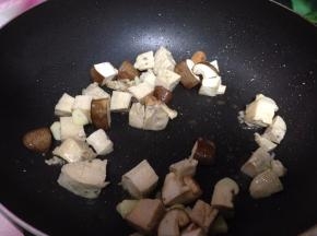 锅内加少许油烧热倒入蒜片炒出香味，随后倒入香菇炒至打蔫