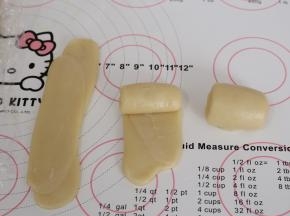 接着来做第二次擀卷，一样将面团收口朝上，用擀面杖从中间往上和往下擀开，这一次尽量擀成长方形的条状，由上往下卷起来。