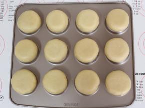 学厨12连不沾乌比派模倒扣过来，全部处理好的面团放在烤盘上，用掌心轻轻压扁。