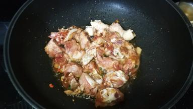 锅里热油倒入腌好的鸡块