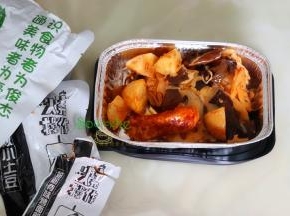 上层盒子取出，把有蔬菜包、硬核的小土豆、烤面筋倒入饭盒，用快赞我松散，接着把调料油倒入拌均。这个油是辣味，根据自己喜欢增减。