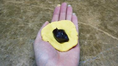 分成小团摊开包入红豆沙捏实压偏