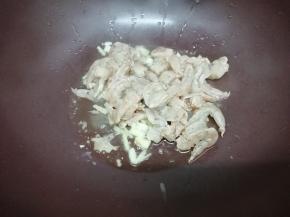 再加入腌制好的虾仁，翻炒到虾仁变红色