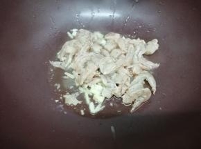 再加入腌制好的虾仁，翻炒到虾仁变红色