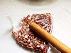 将花生米放入一个食品袋内，用擀面杖敲打数下成大颗粒即可。