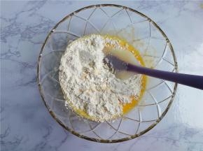 接着筛入低筋面粉，用刮刀翻拌均匀，面糊无干粉，无颗粒即可，把面糊放一边静置片刻。