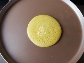 锅中松饼煎制一会就出现密集的泡泡，就可翻面继续煎制。