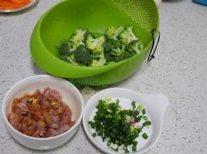 等待煮粥的时间，把西兰花切小朵，洗净捞出。猪瘦肉洗净切薄片，放酱油、生粉、油、盐、生姜丝拌均。香葱洗净，切好。