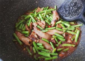 最后倒入点清水，把锅中食材煮沸，焖下让豇豆熟透即可。
