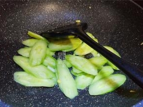 把炒好的鸡蛋盛出，再倒入少许油脂，把蒜瓣切片爆香，黄瓜去皮切片倒入翻炒。