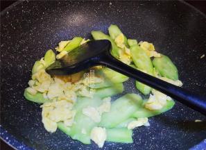 翻炒片刻后，撒入少许盐，接着把鸡蛋块倒入跟黄瓜片一起翻炒。