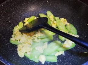 翻炒片刻后，撒入少许盐，接着把鸡蛋块倒入跟黄瓜片一起翻炒。