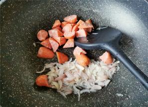 热锅倒入少许橄榄油，升温后把洋葱碎倒入翻炒变软，再把牛肉场也倒入一起翻炒好备用。