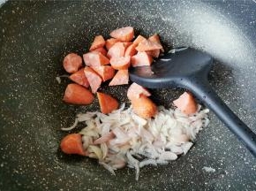 热锅倒入少许橄榄油，升温后把洋葱碎倒入翻炒变软，再把牛肉场也倒入一起翻炒好备用。