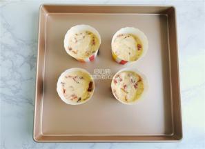 备一个学厨的烤盘，放入纸杯模具，混合好的面糊均匀分到杯子中。