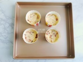 备一个学厨的烤盘，放入纸杯模具，混合好的面糊均匀分到杯子中。