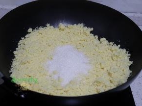 把打碎的绿豆泥倒入炒锅里，接着倒入白砂糖，炒至白砂糖软化溶解。接着放麦芽糖，炒均。