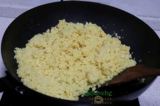 倒入猪油，翻炒均匀，炒至绿豆能合成团，淡淡的清香味飘出。炒绿豆泥一定要用小火翻炒，旺火容易炒糊且炒不干水，难成团。