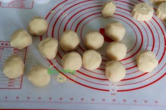 炒好绿豆泥，用一个大盘子摊开，放通风处，放凉至不烫手状态，分50克一个，揉成小团