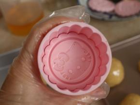 取出学厨月饼模（75g HelloKitty款），卡入花片。在花片和模具周围刷一层薄薄的油。