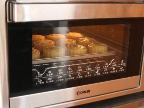 将全部印好的月饼连带烤盘，送入预热好的东菱烤箱，上下火190℃，中层，烘烤5分钟，让月饼花纹定型。