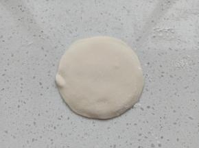 取白色面团擀成中间厚边缘薄的面片