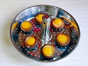 焯水的香菇摆放在升降网中，再磕入鹌鹑蛋。