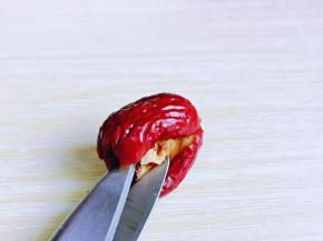 再用剪刀的尖部，夹住枣核，如图。