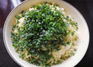 因盐的加入，白菜会出水，攥掉多余的水分，把小葱切细圈倒入白菜盆中混合。