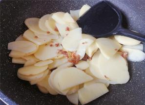 把土豆片倒入锅中跟肉末一起翻炒，土豆变透明色。