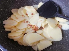 把土豆片倒入锅中跟肉末一起翻炒，土豆变透明色。