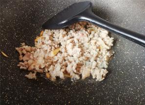 热锅冷油，升温后把蒜瓣切片倒入爆香，猪绞肉冲洗下倒入锅中翻炒变色。