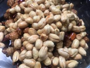 再倒入辣椒酥和花生仁，炒匀