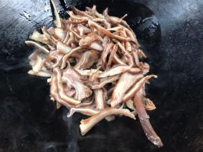 放入猪耳朵，煎炒至表面微黄