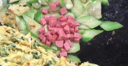 加入火腿肠丁，翻炒均匀