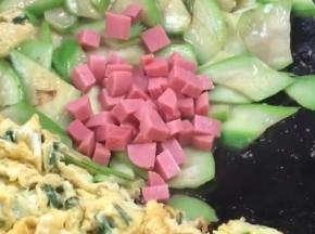 加入火腿肠丁，翻炒均匀