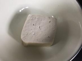 豆腐冲洗一下，放入大点的容器中