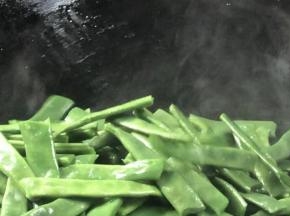 再起锅不放油，放入四季豆炒干水分