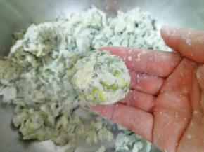 然后用手来回搓，直到面粉和槐花完全粘合在一起，能捏成团，如图。