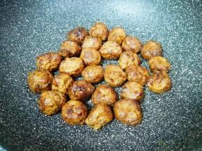 不粘锅内倒入少许食用油烧热，下入解冻的肉丸，开小火用铲子来回翻动，直至肉丸表皮变脆，关火盛出备用。