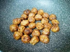 不粘锅内倒入少许食用油烧热，下入解冻的肉丸，开小火用铲子来回翻动，直至肉丸表皮变脆，关火盛出备用。