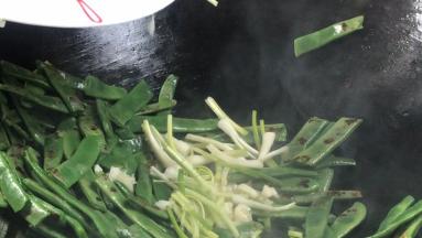 加入葱段和蒜末，翻炒均匀