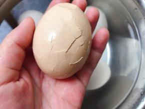 用勺子背把那个鸡蛋壳敲碎，尽量敲的细碎些方便入味