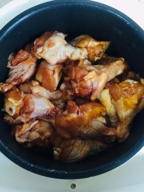 把腌制好的鸡腿放在葱段上。