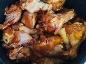 把腌制好的鸡腿放在葱段上。