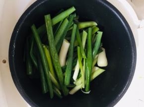 葱洗净切成段儿，均匀的铺在电饭锅底部。